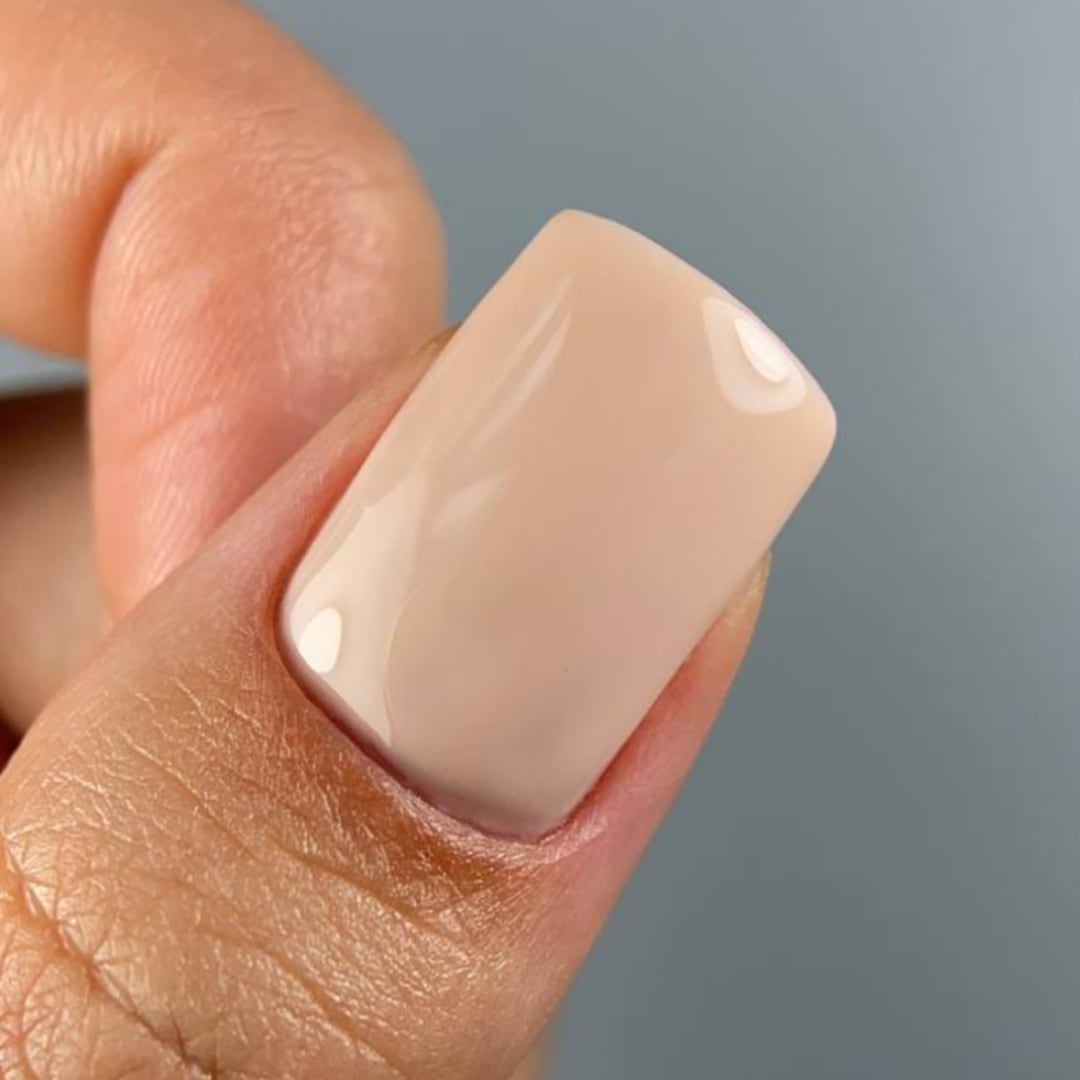 Close-up of a nail painted with Paloma gel polish in shade C070 from the Nude Collection, a warm beige tone perfect for a natural nude manicure or a subtle French look. This highly-pigmented, long-lasting gel polish delivers a flawless, glossy finish.