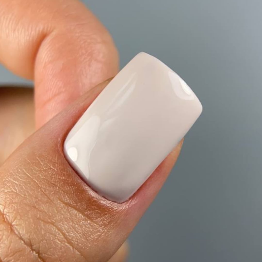 Paloma Nude Gel Polish C075. Close-up of a nail painted with Paloma gel polish in shade C075 from the Nude Collection, a soft nude tone perfect for a natural, elegant manicure. This highly-pigmented, long-lasting gel polish provides a smooth, glossy finish, ideal for a classic look or French manicure base.