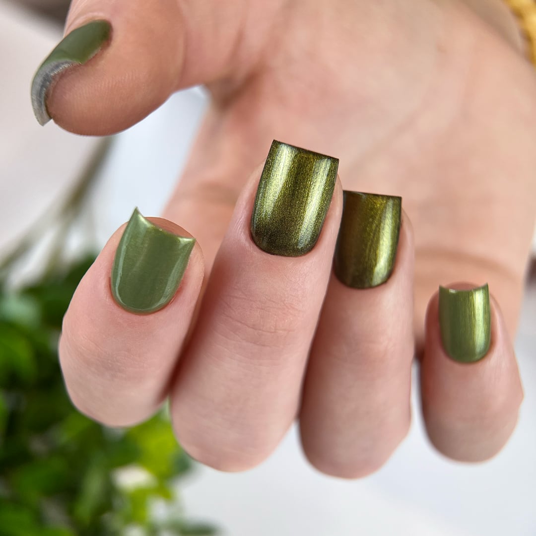 Close-up of a manicure with Paloma Magic Top T004, a golden top coat applied over black and olive gel polish, creating a chrome-like effect. This metallic, reflective finish adds a luxurious golden shimmer, showcasing the versatility of Paloma's Magic Top for a bold and sophisticated look